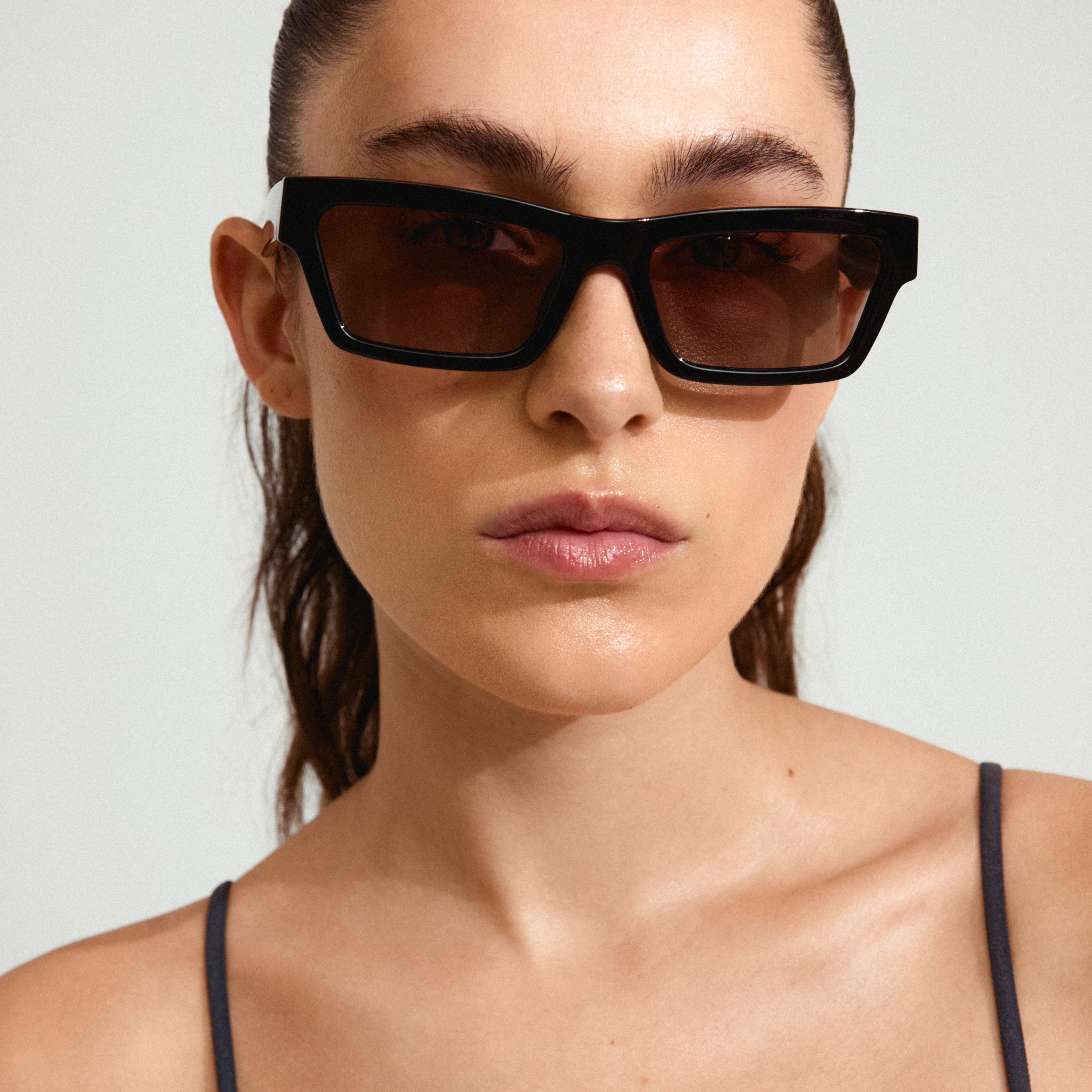 Woman showcasing ASHLYN sunglasses by Pilgrim, highlighting their angular design and trend-forward elegance, ideal for stylish spring outings with UVA/UVB protection.