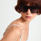 Woman with short red hair wearing ANIYAH sunglasses black, featuring oversized angular frames and ultra-wide temples, embodying a trendy, movie-star aesthetic.