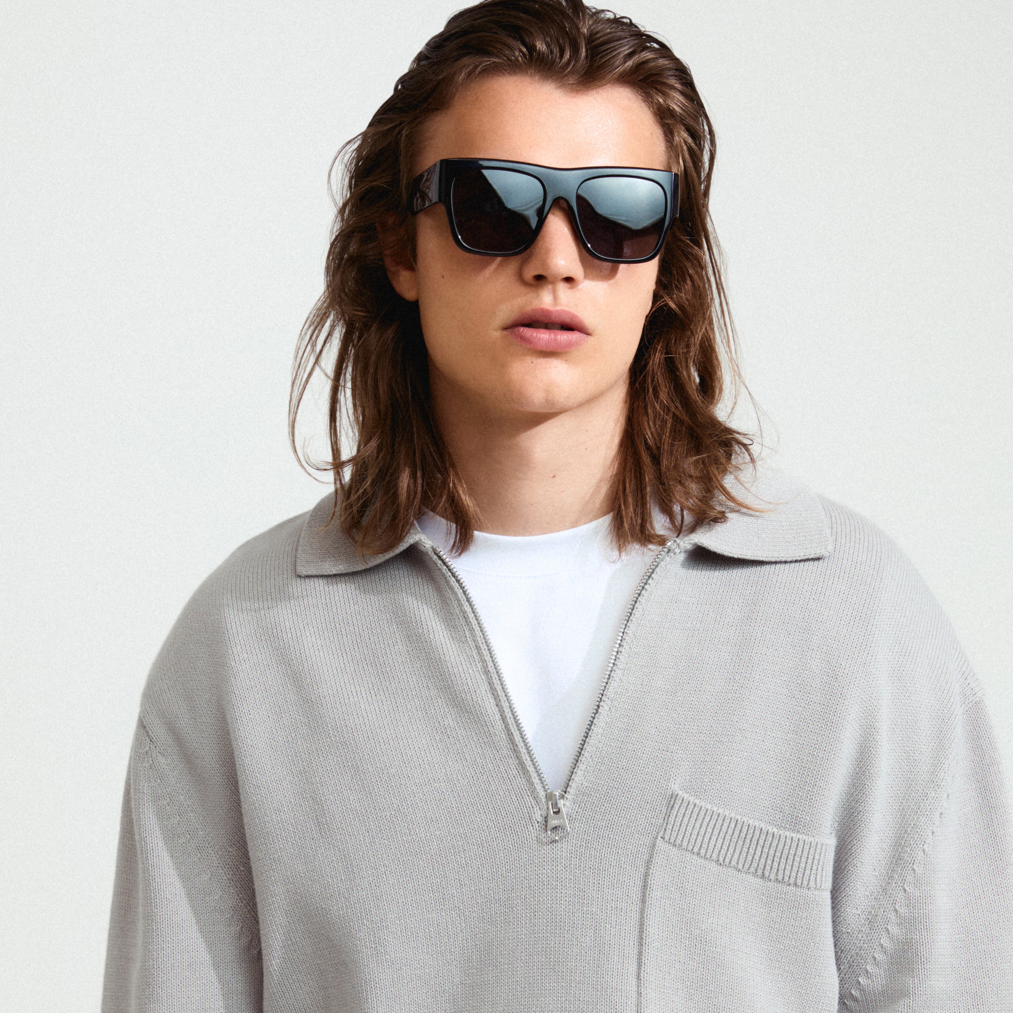 ANIYAH sunglasses black featuring oversized angular frames and dark lenses, worn by a person with long hair, showcasing a stylish and trendy design.