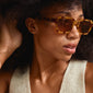 Woman wearing ANNALISE sunglasses tortoise brown, featuring an angular frame and orange lenses, perfect for summer style.