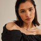 MSF necklace featuring a silver-plated coin pendant with the MSF logo on a woman's neck, showcasing its playful, colourful design.