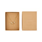 Gold-plated MSF charity necklace featuring letter charms, freshwater pearls, and a red micro pearl, presented in a brown box. Supports Doctors Without Borders.
