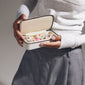 Person holding Pilgrim's Light Sand Medium Jewellery Box, showcasing its compact design with compartments for organizing rings, earrings, necklaces, and bracelets.