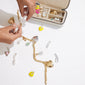 Person holding Pilgrim's Light Sand Medium Jewellery Box, showcasing its compact Scandinavian design with organized compartments and sturdy zipper closure for travel.