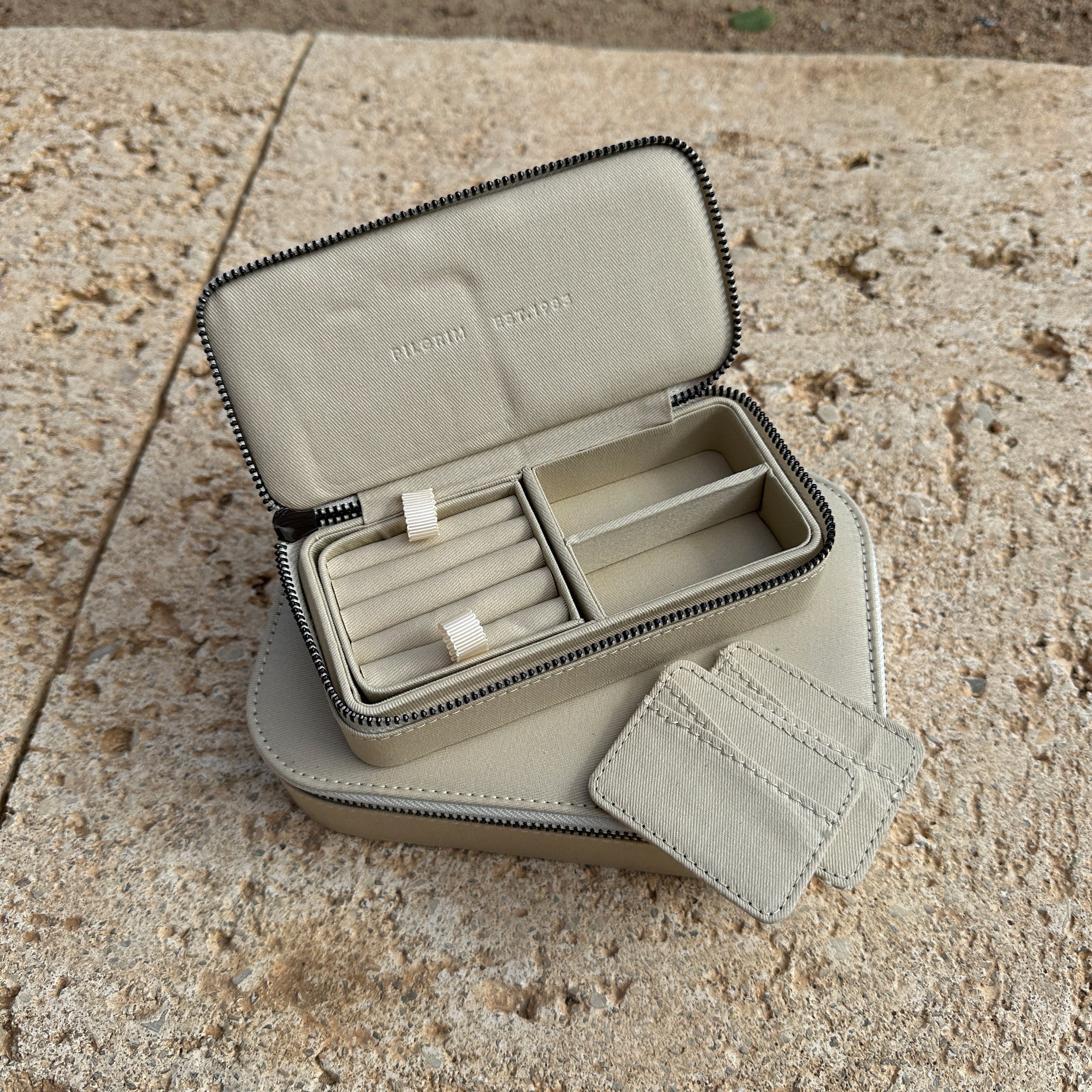 Jewellery box, Light Sand, Medium: A compact, Scandinavian-style jewellery organizer with a zipper, featuring compartments and pockets for rings, earrings, necklaces, and bracelets.
