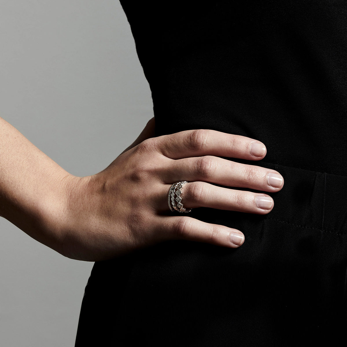Close-up of a hand wearing the JOY silver-plated ring, showcasing its slender, detailed design suitable for a boho-inspired, stacked look.