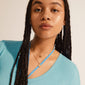 HAVEN 2-in-1 coin necklace gold-plated, elegantly layered on a young person, showcasing delicate pendants and dynamic chain links for a contemporary bohemian style.