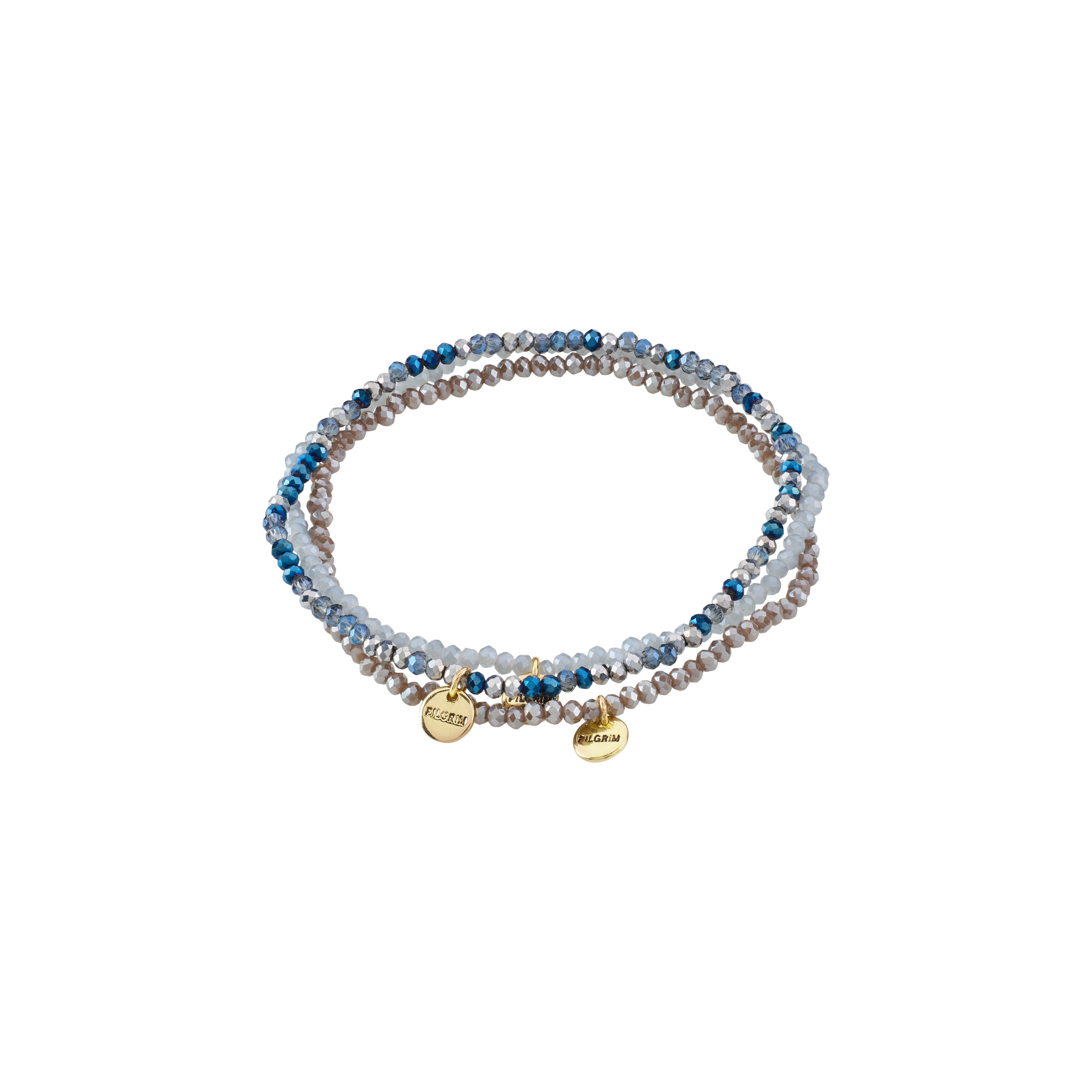 INDIGO 3-in-1 bracelet set features stackable, beaded strands in blue-grey hues with gold-tone charms, including a Pilgrim-stamped piece, on durable elastic.
