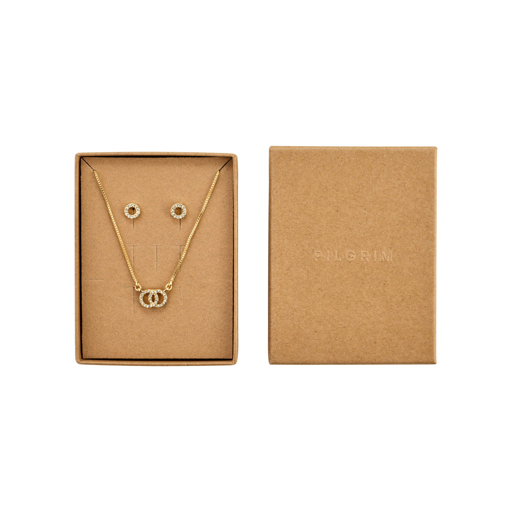 HARLAN gift set: Open kraft box with gold-plated necklace featuring interlocking crystal circles and matching stud earrings, reflecting Pilgrim's elegant, eco-friendly Scandinavian design.