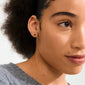 Close-up of a young person wearing a gold heart earring from the HALO gift set, highlighting the earring's delicate design against their natural, minimal-makeup look.