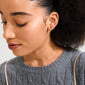 Young woman wearing HALO gift set earrings: a tiny stud and thin gold hoop, showcasing the 3-in-1 gold-plated, eco-friendly collection by Pilgrim.