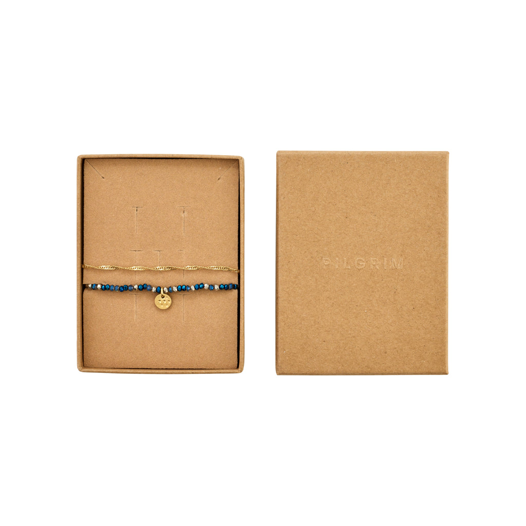BELLAMY gift set featuring two bracelets: a twisted gold-plated chain and a blue bead strand with a gold-tone disc charm, in a kraft-board box.