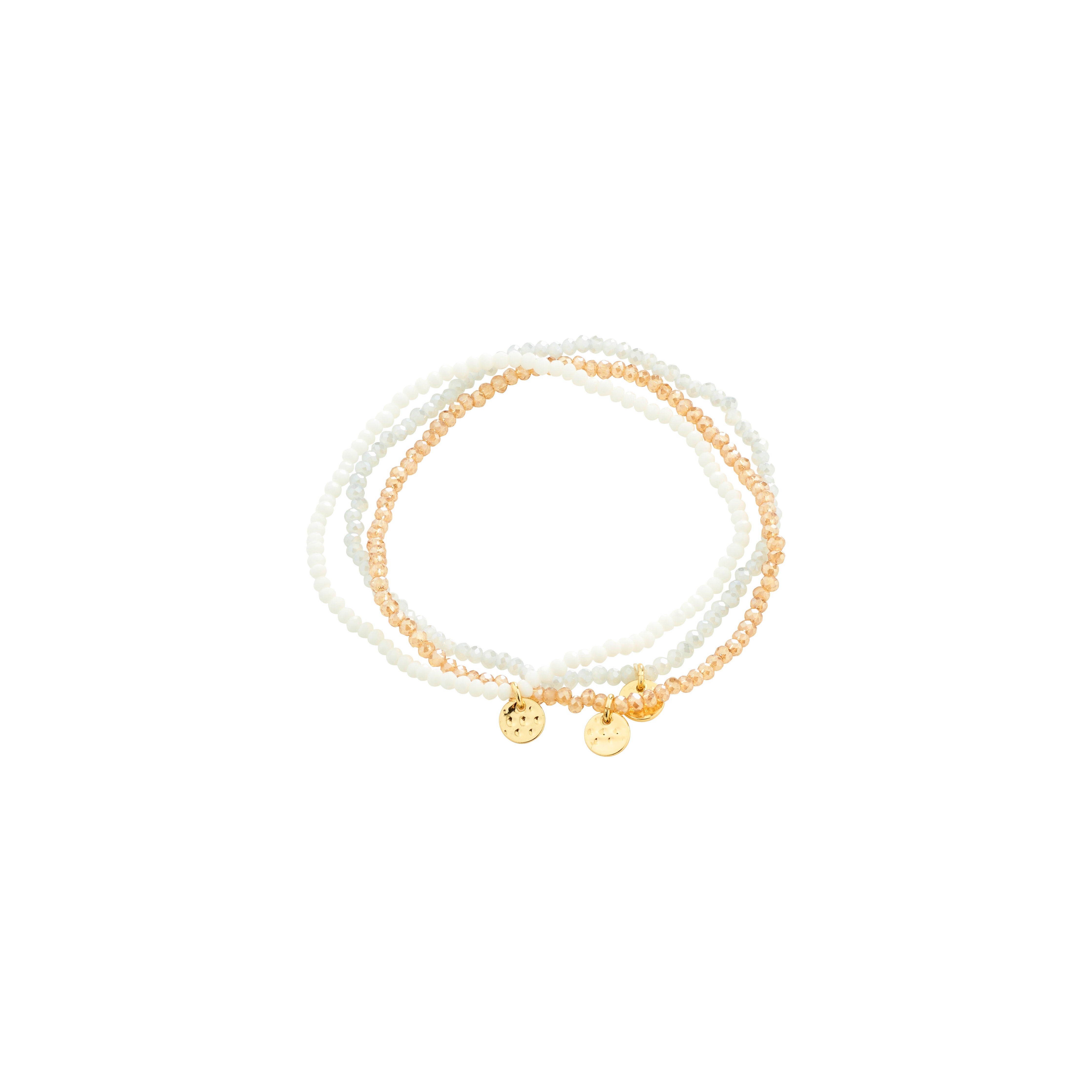 INDIGO 3-in-1 bracelet set with delicate stretch beads in white and peach, featuring gold-tone disc charms, perfect for stacking and versatile wear.